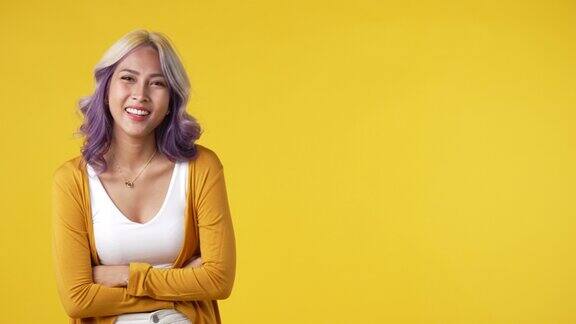 年轻的亚洲女子指着空白的文字在黄色背景孤立的拷贝空间