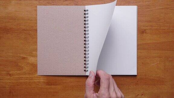 4k:木制背景上带空白页的手打开笔记本停止运动