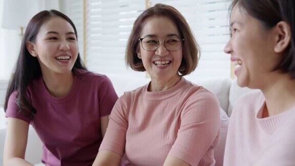一群亚洲女人坐在一起谈笑风生在粉红戴乳腺癌