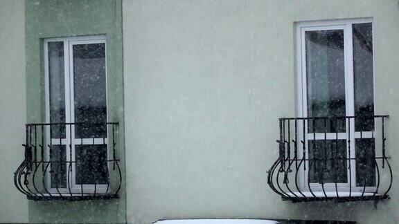 房子的窗户映衬着小雪花飞舞
