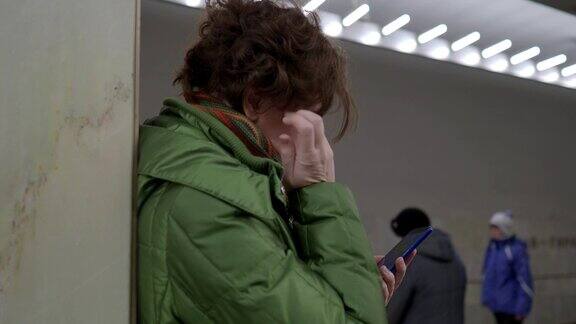 一名女子在地铁站使用智能手机