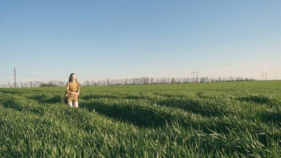 在阳光明媚的夏日快乐的微笑的小女孩在绿色的田野上奔跑