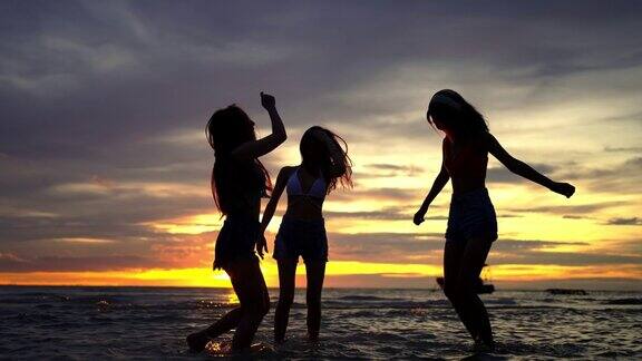 女子在夏日夕阳下的热带海岛海滩上跳舞