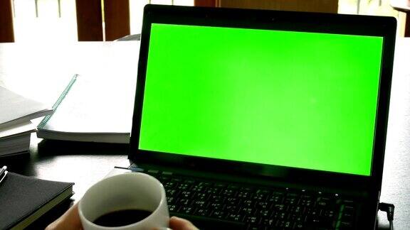 摄影:商务人士使用笔记本电脑与绿色屏幕为色度键办公桌子-商业概念