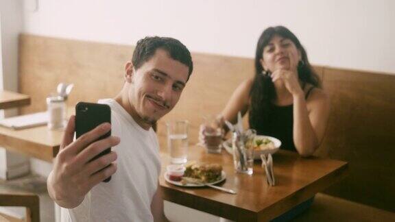 年轻的拉丁美洲夫妇在餐厅自拍