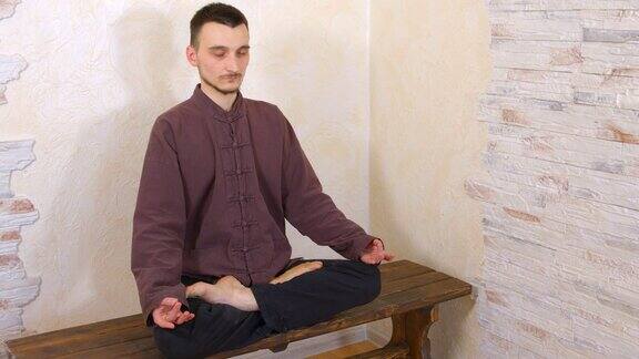 沉思的人在莲花姿势练习禅宗冥想瑜伽人坐在荷花姿势练习放松练习在木长凳上