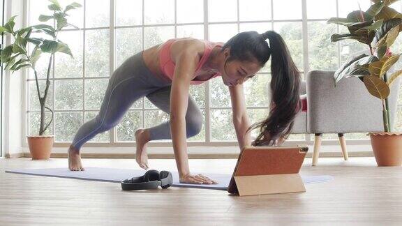 美丽的亚洲女性在隔离期间在家做平板支撑运动训练