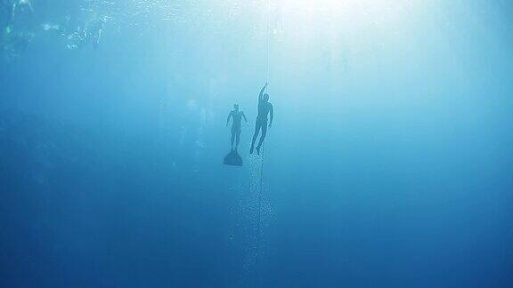 自由潜水者在海里沿着绳索上升