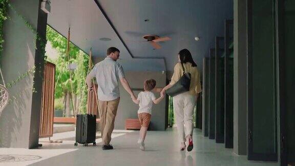 母亲和父亲牵着孩子的手走在酒店里
