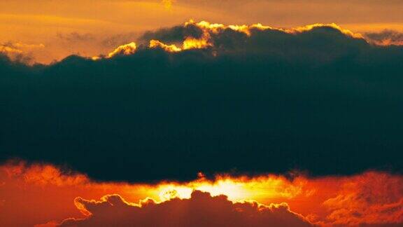 亮橙色的日落日落在云层后面
