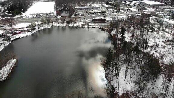 新泽西州伦道夫郊区丘陵湖泊下雪的航拍视频