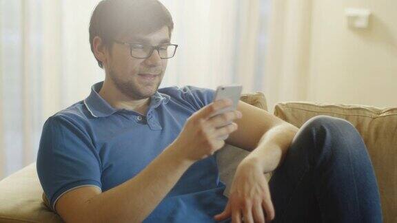 一名男子坐在沙发上通过电话视频聊天
