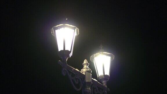 优雅的老式路灯上有两盏灯晚上点着