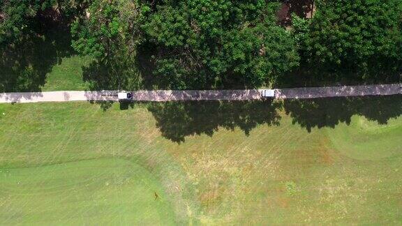 4K鸟瞰图一群亚洲人坐在高尔夫球场的高尔夫球车上夏日阳光明媚