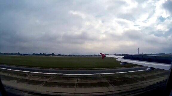 透过窗户可以看到飞机降落到机场的画面