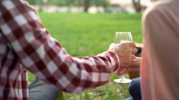 退休的丈夫把红酒倒进酒杯招待漂亮的妻子约会