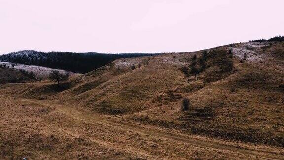 无人机拍摄的乡村地区有山丘和枯死的植被在秋天的白天