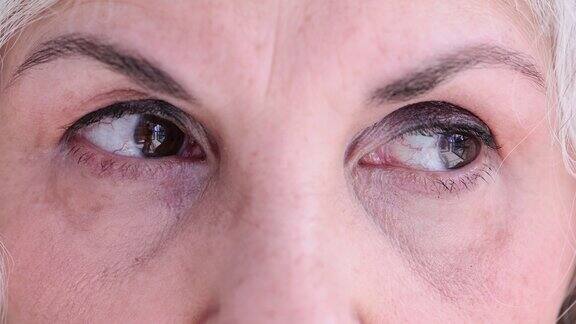 棕色眼睛的老妇人正在做眼保健操