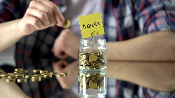 房字上面玻璃罐带钱储蓄观念投资房地产