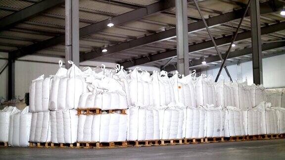 大袋的谷物产品袋子一排排地堆放在工业仓库里