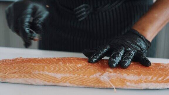 一名日本厨师正在从三文鱼中去除鱼刺