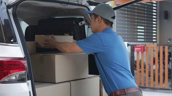 快递员将包裹装在纸板箱里并在发送给客户之前检查包裹的库存上门交付