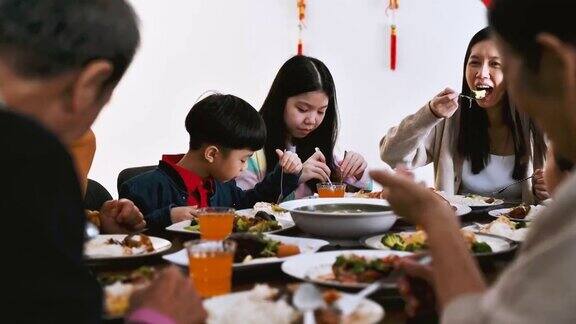 中国农历新年欢乐的亚洲一家三口欢聚一堂共进年夜饭