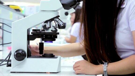 医学生用显微镜观察细菌特写
