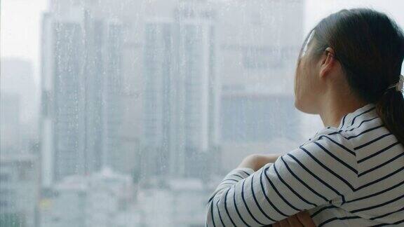 女人看着窗外的雨滴