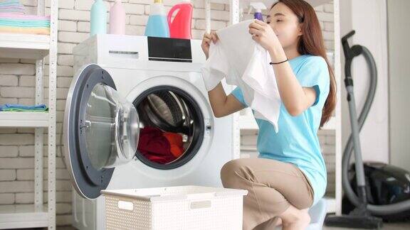 一个女人从洗衣机里拿出衣服