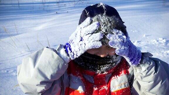在冬季公园的雪地上快乐的男孩的肖像