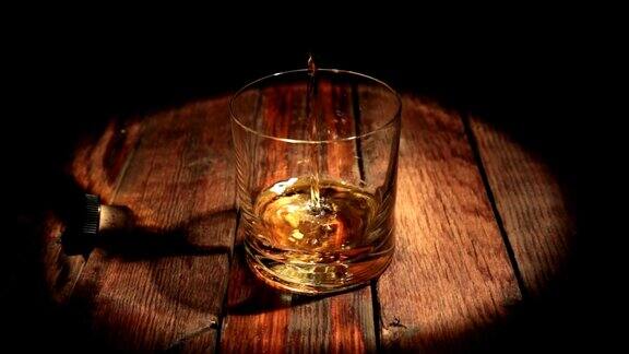 在光线的照射下从瓶子里倒威士忌一杯朗姆酒