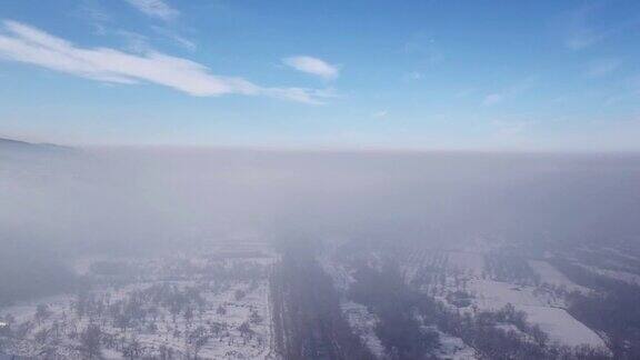 冬天的村庄和公路上汽车在雾中行驶