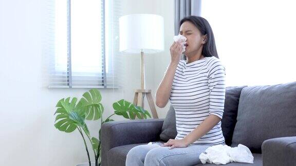 年轻的亚洲妇女感冒了她打了个喷嚏流鼻涕