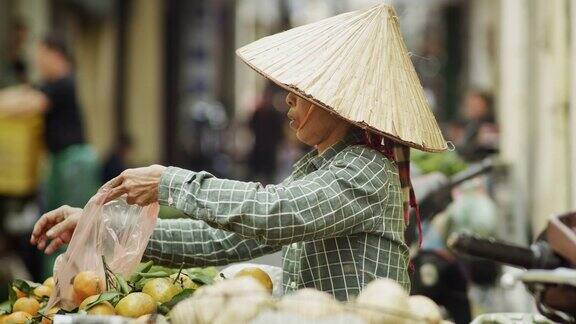 手持的越南妇女在市场上卖水果