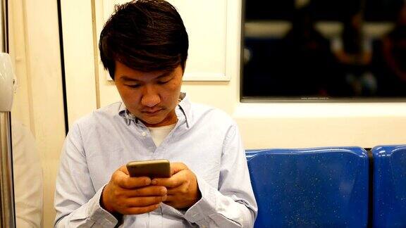 亚洲男人在火车上使用手机