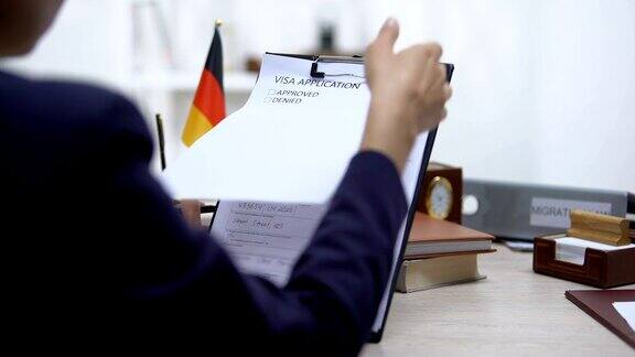 使馆工作人员批准签证申请桌上放德国国旗授权