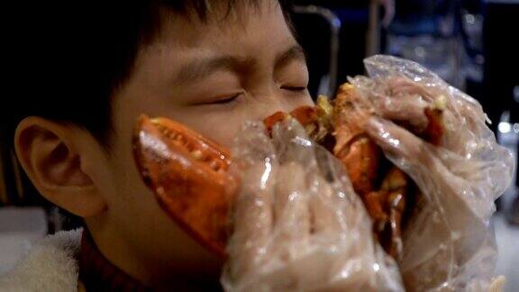 男孩在室内吃芝士焗龙虾