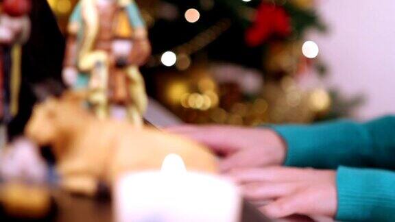女孩坐在圣诞树旁用手弹钢琴