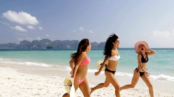穿着比基尼的女孩在海滩上跑步快乐的妇女在暑假里组织游客