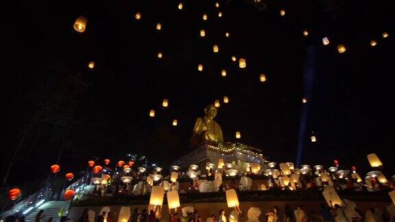在泰国北部的兰汶水灯节上漂浮的灯笼被抛向大佛上空