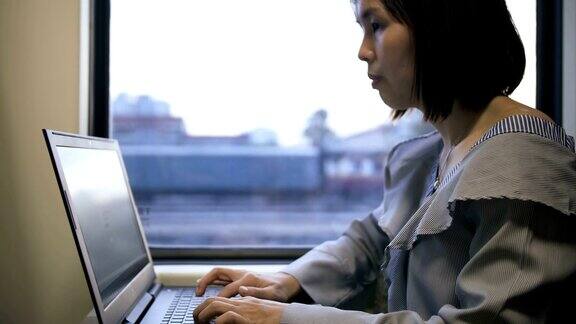 女人在火车上用笔记本电脑