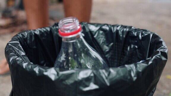 用手把塑胶水瓶扔进回收箱