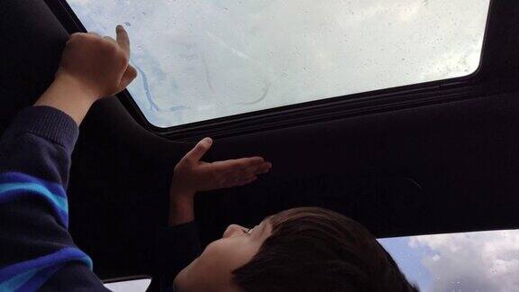 小男孩在冒热气的车窗上画画