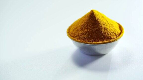 黄色香料白色背景下分离的一碗磨碎的姜黄