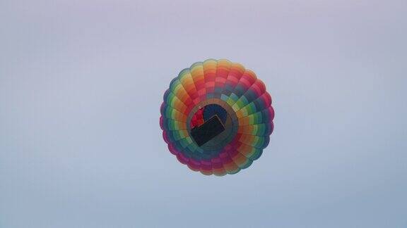 日出时彩色热气球在空中飞行的慢镜头俯视图