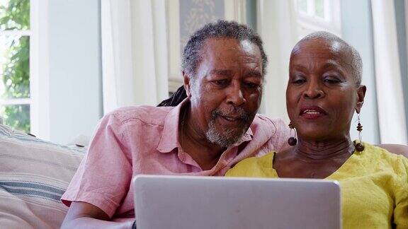 一对老年夫妇用笔记本电脑与家人进行视频通话