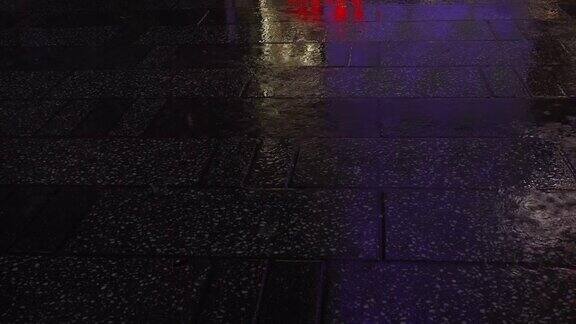 人们在雨天晚上走在人行道上