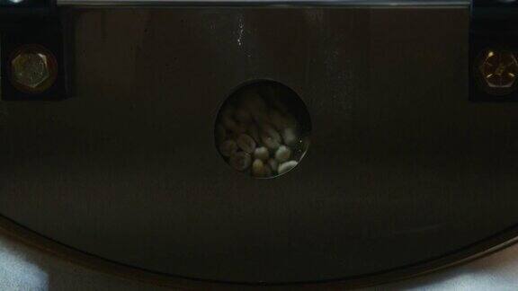 手持式特写镜头的咖啡豆烘烤在一个工业咖啡烘培机