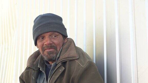 一个无家可归的人在室外谈话乞丐坐在街上